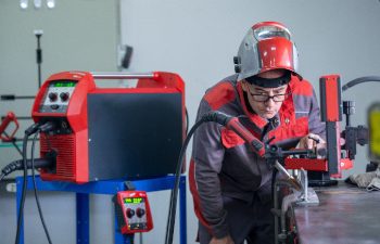 Professional welder checking Industrial automotive spot welding machine in factory. Professional welder checking Industrial automotive spot welding machine in factory.